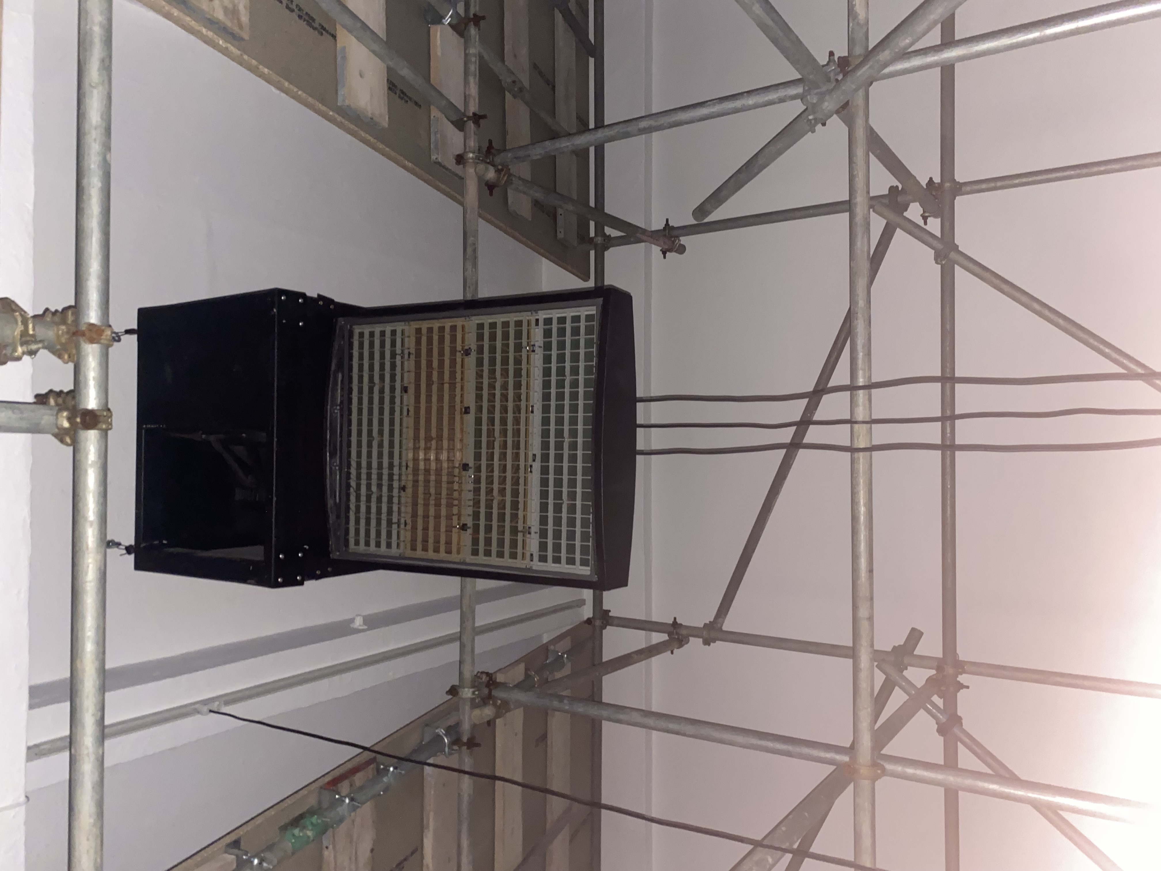 Close detail of the suspended STILL LIFE hardware system within the scaffold structure.